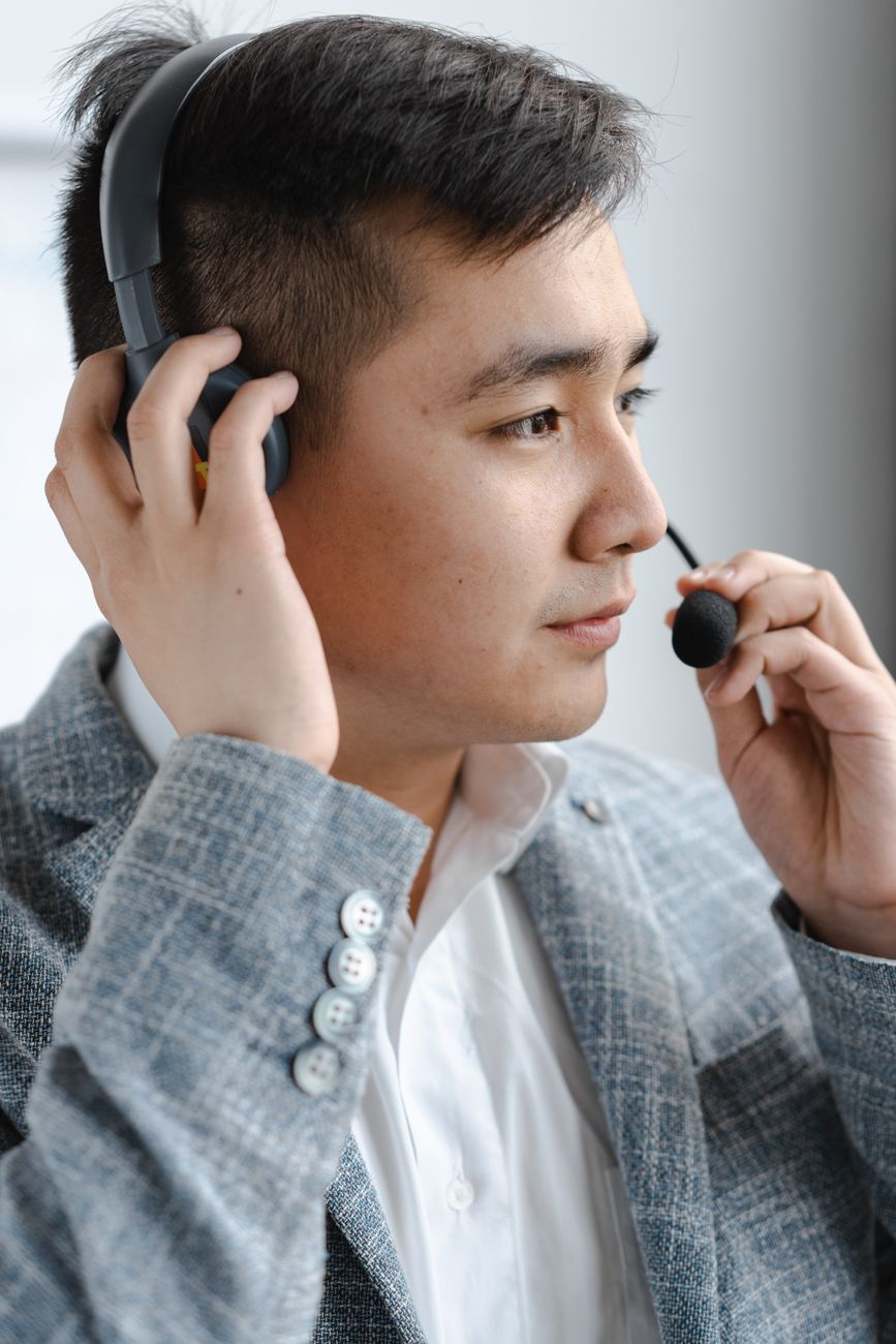 Office worker wearing a headset while reviewing call information on a computer screen