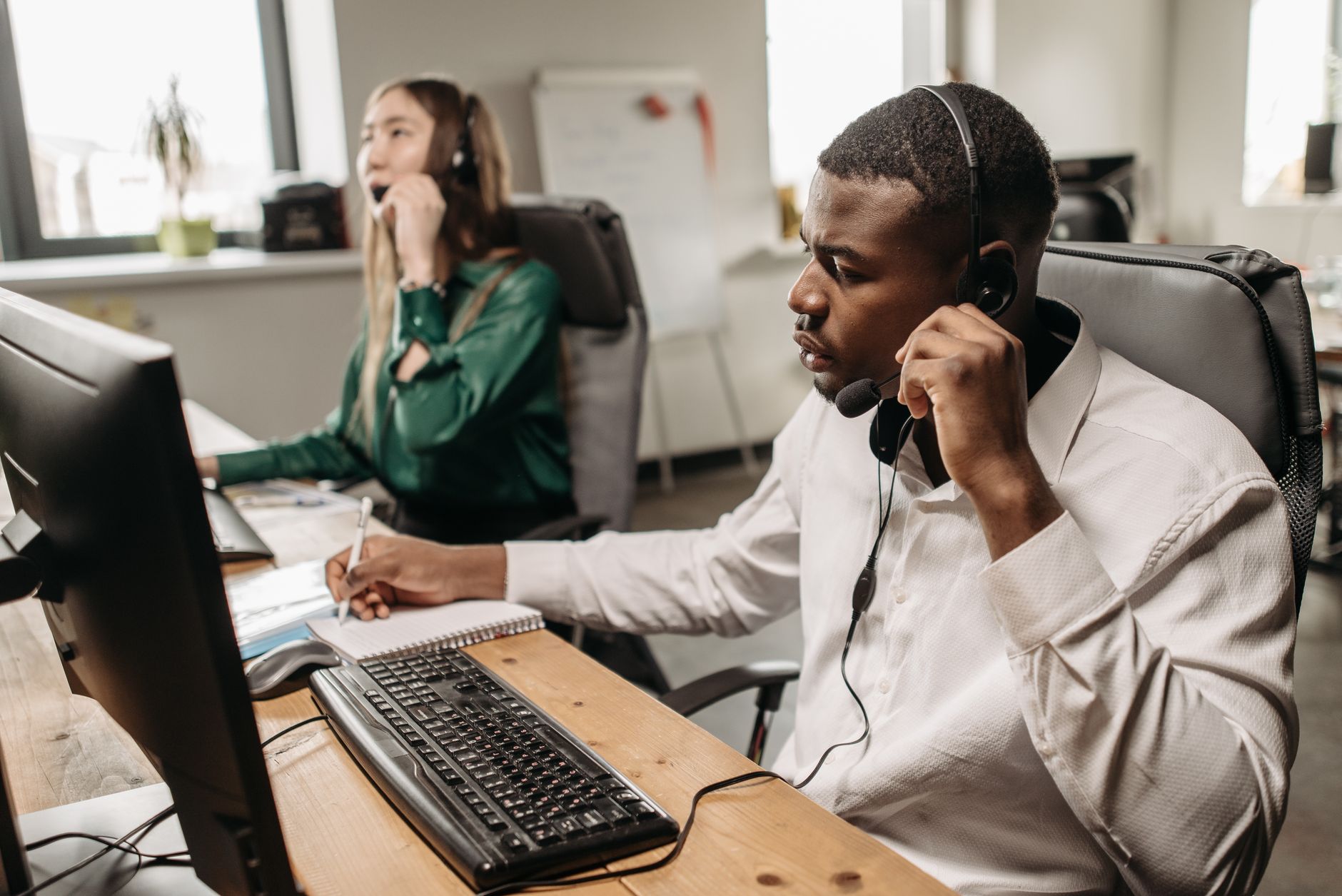 Live answering service operator wearing a headset while answering a call at a desk
