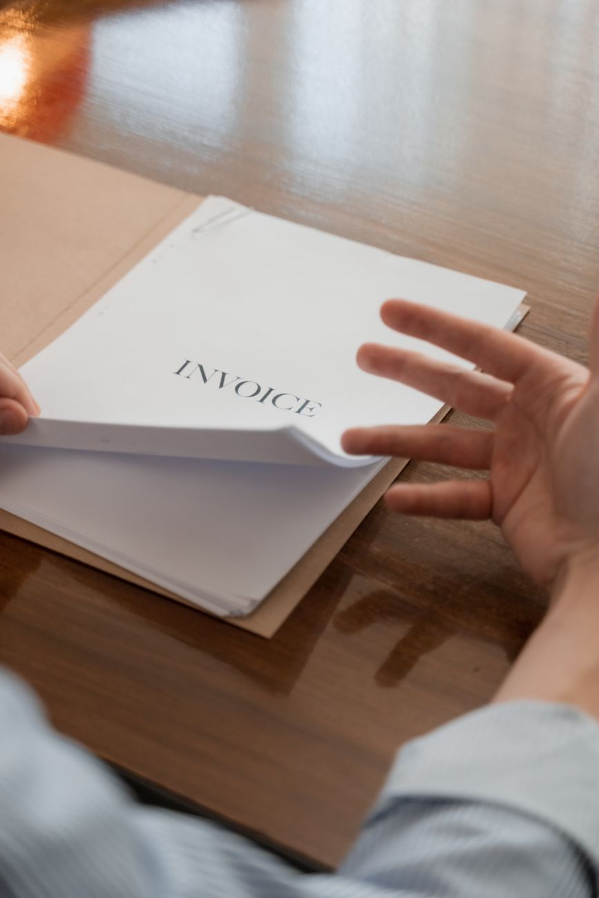 Small business owner reviewing a monthly subscription invoice and usage details at a desk