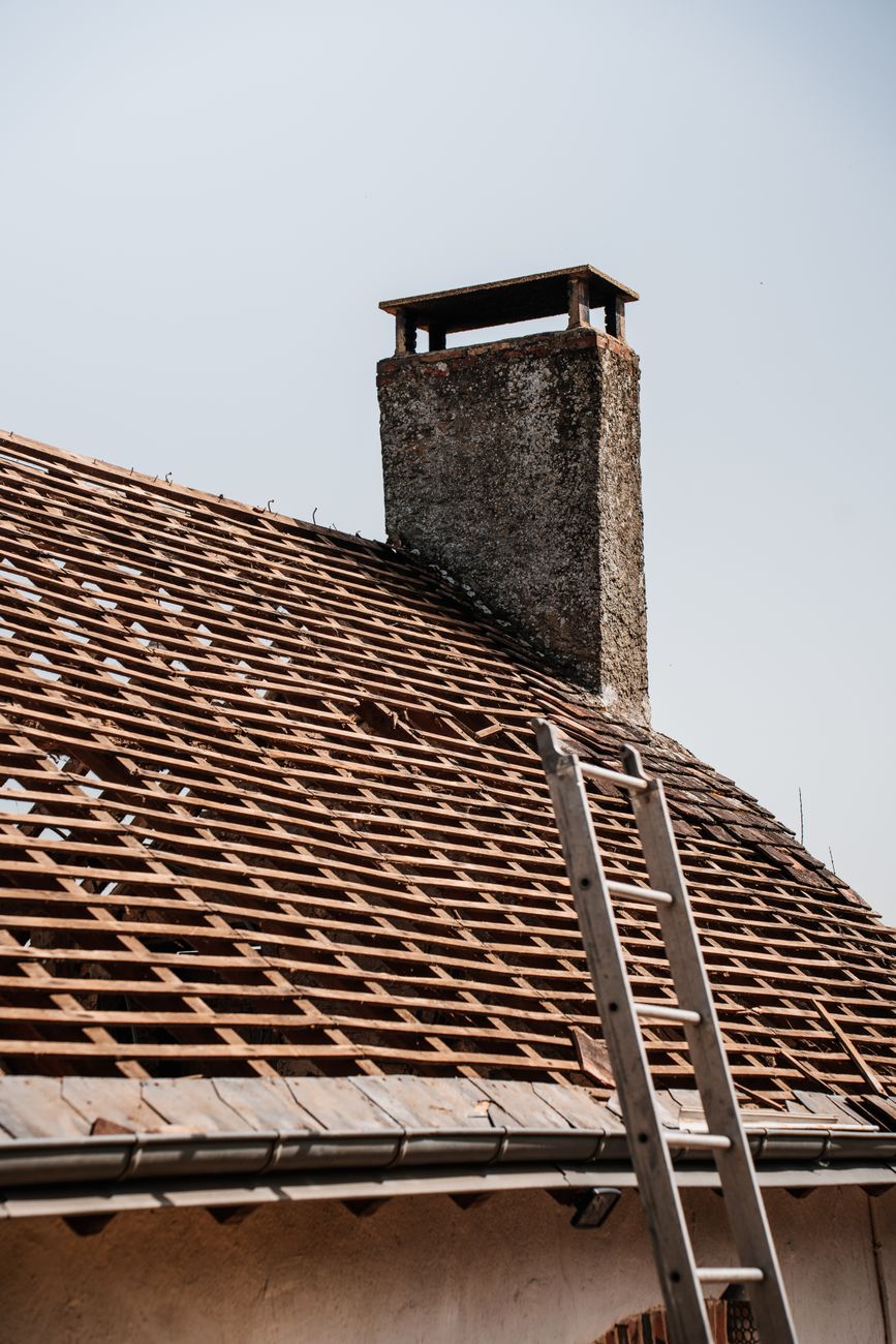 Roofing contractor working on a rooftop while an office call is being handled remotely