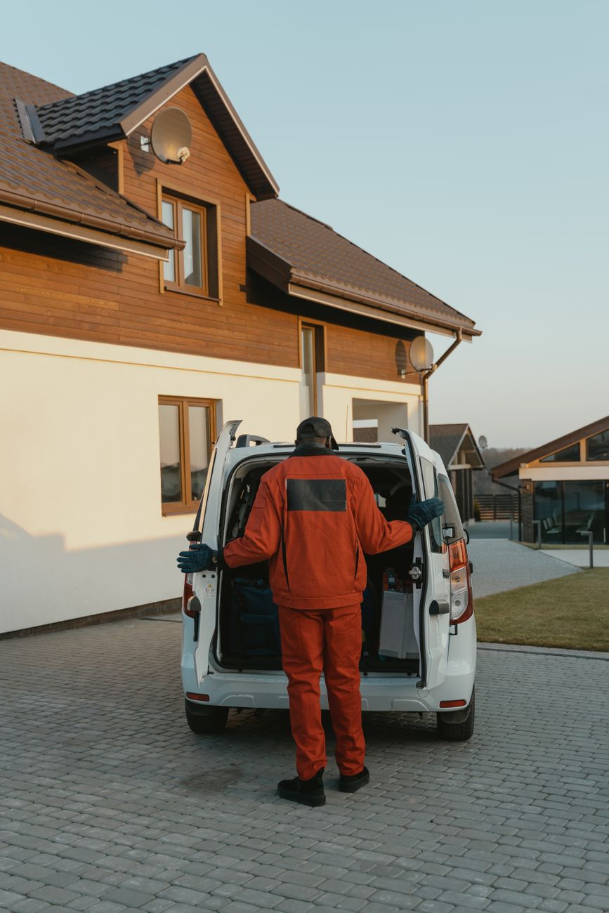 Pest control technician arriving at a residential property for a scheduled treatment