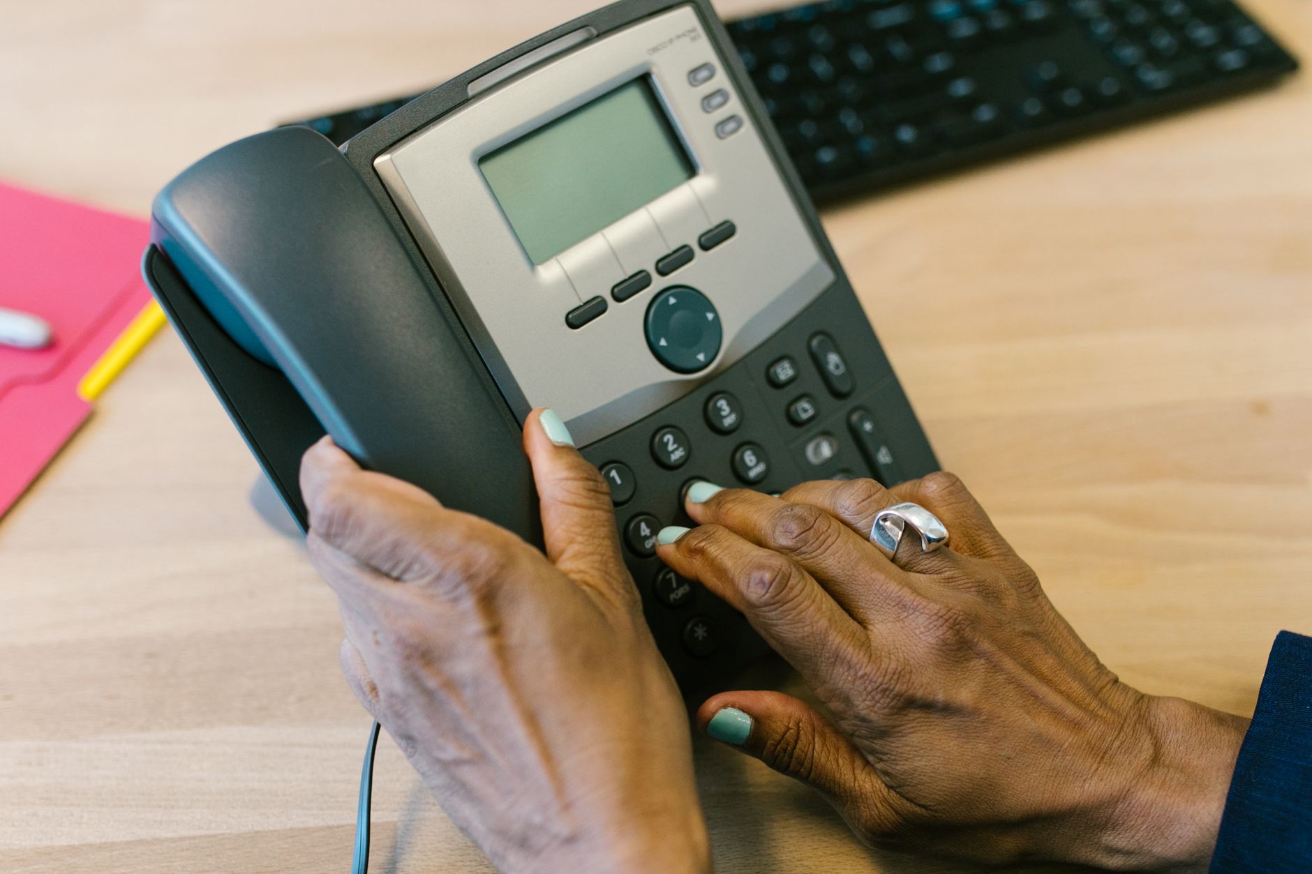 Unanswered office phone with voicemail indicator light on a desk