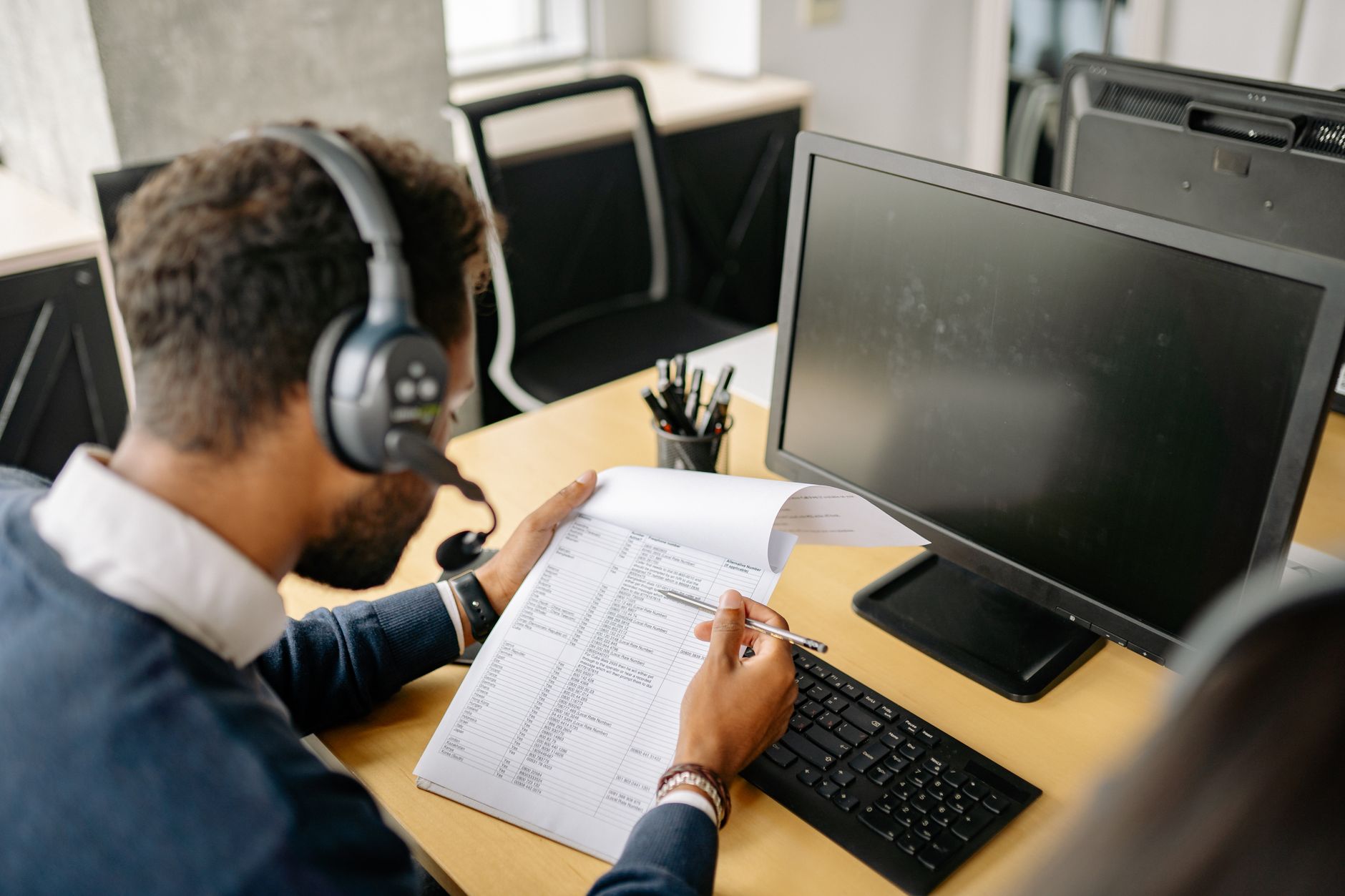 Office worker reviewing a written call transcript at a desk